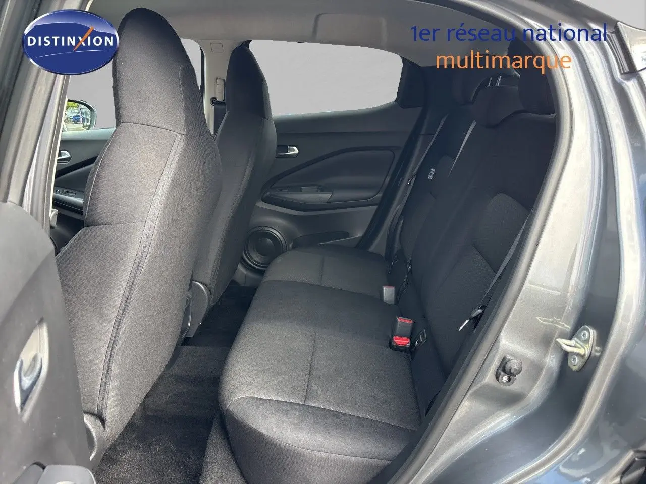 Vue intérieure côté droit montrant les sièges arrière en tissu noir du Nissan Juke Hybrid 2024 gris squale métal.