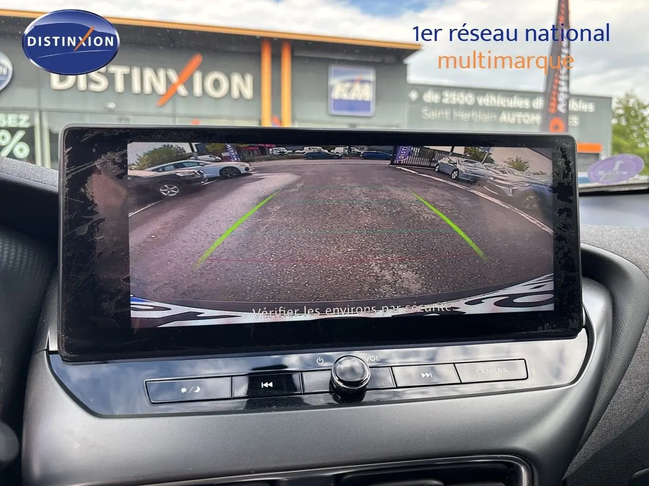Vue intérieure de l'écran multimédia affichant la caméra de recul du Nissan Juke gris squale metal 2024 en stationnement.