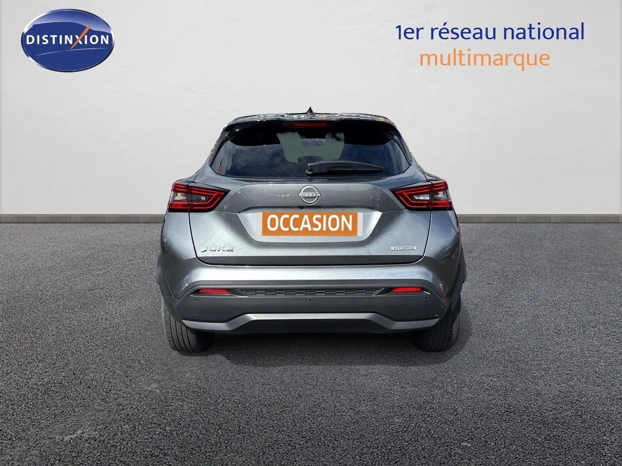 Vue arrière d'un Nissan Juke Hybrid 143ch Business Edition gris squale metal, avec feux LED et plaque "OCCASION".