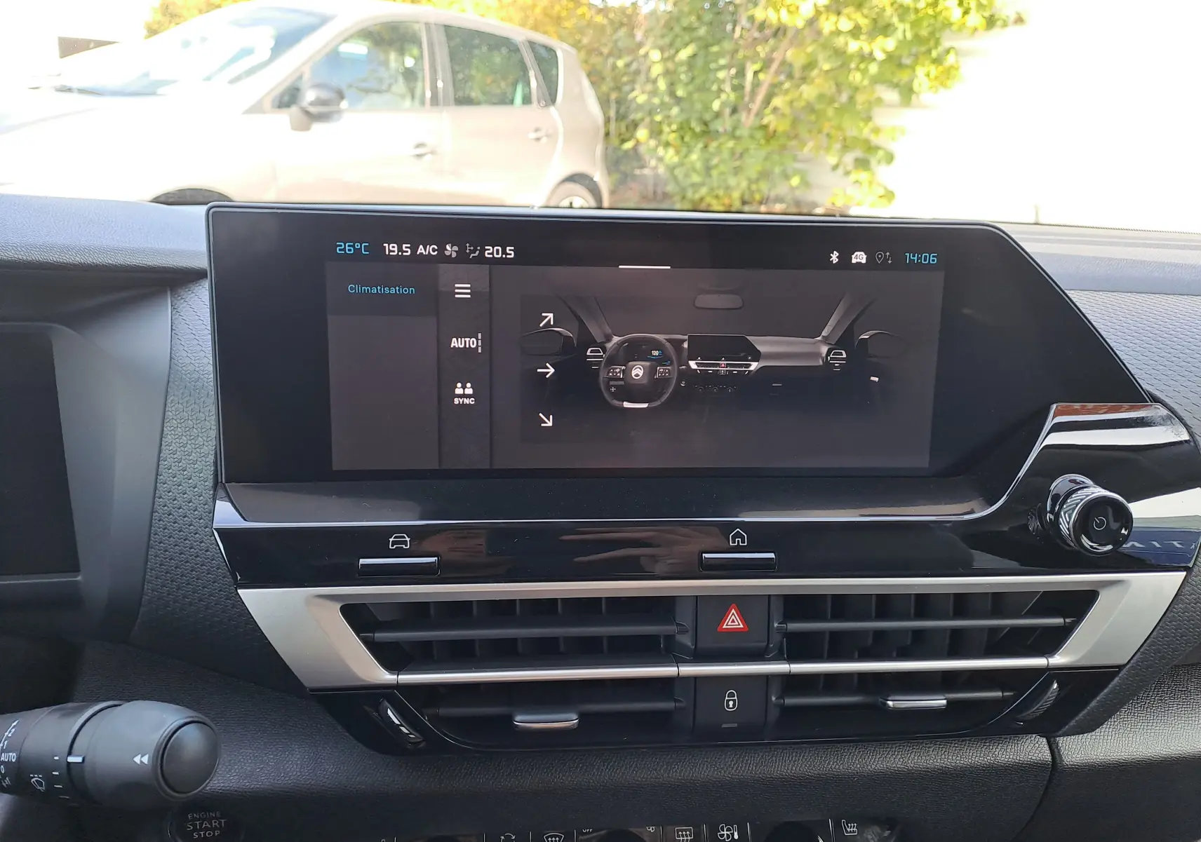 Vue rapprochée de l’écran central tactile du tableau de bord de la Citroën C4 hybride 2025, ambiance intérieure gris noir.