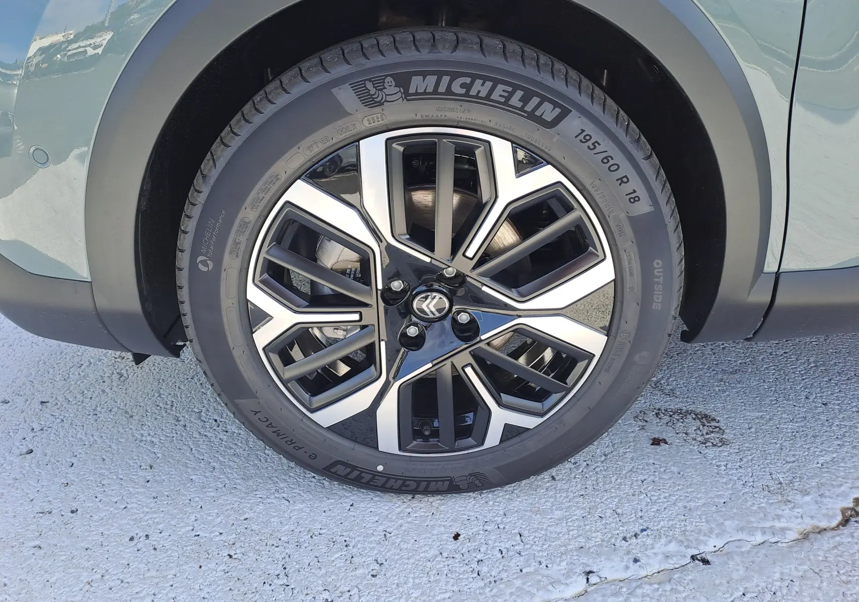 Gros plan sur la roue avant gauche d'une Citroën C4 hybride Manhattan Green avec jante alliage bicolore et pneu Michelin.