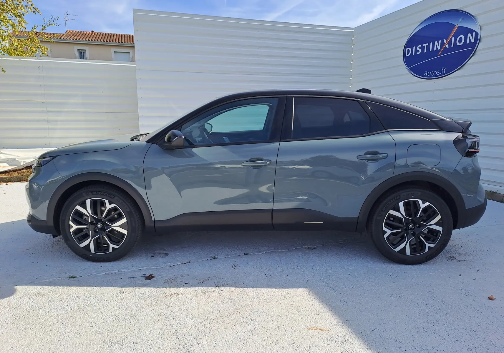 Profil côté gauche de la Citroën C4 hybride 2025 en Manhattan Green avec toit noir et jantes bi-ton.