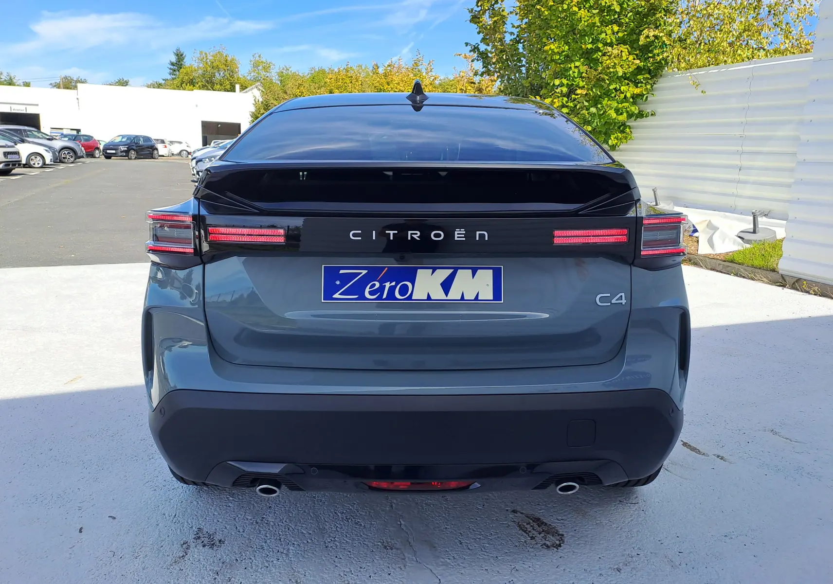 Vue arrière du Citroën C4 hybride Manhattan Green avec toit noir, feux LED et double sortie d’échappement visible.