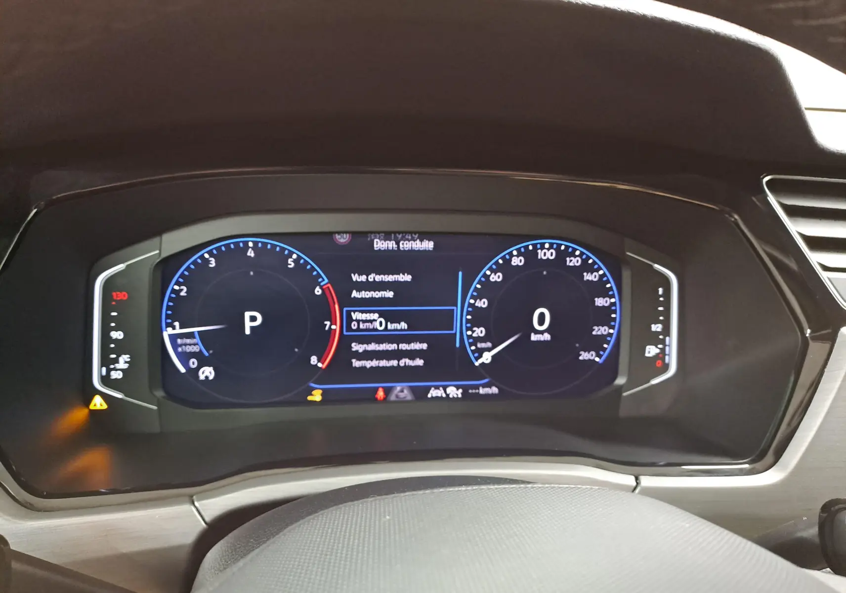 Vue rapprochée du tableau de bord numérique du Volkswagen Touran 2025, affichage vitesse et informations de conduite.