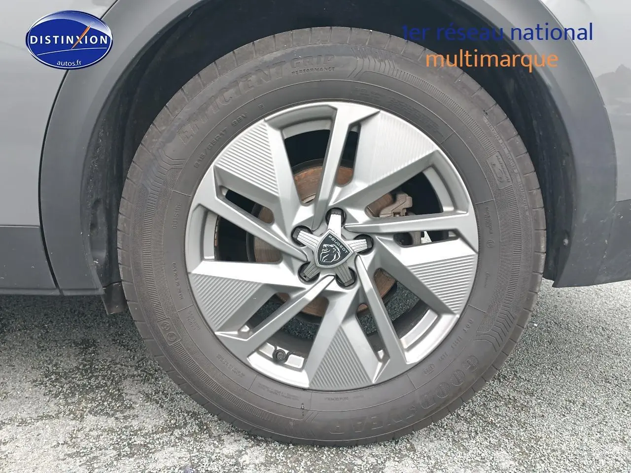 Gros plan sur la jante alu grise avec logo Peugeot d’un PEUGEOT 408 gris sellenium, vue côté droit.