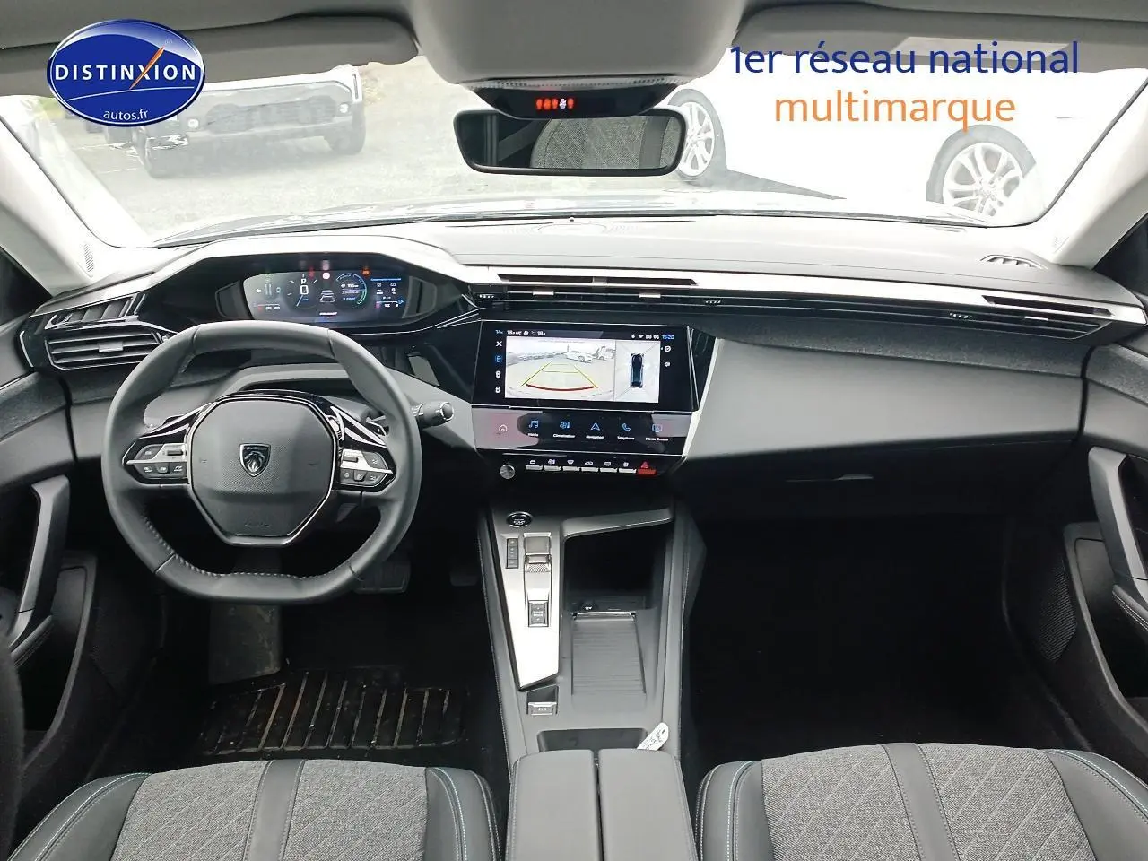 Vue intérieure avant du Peugeot 408 Hybrid 145 allure 2024, tableau de bord moderne avec écran tactile et volant multifonction cuir.