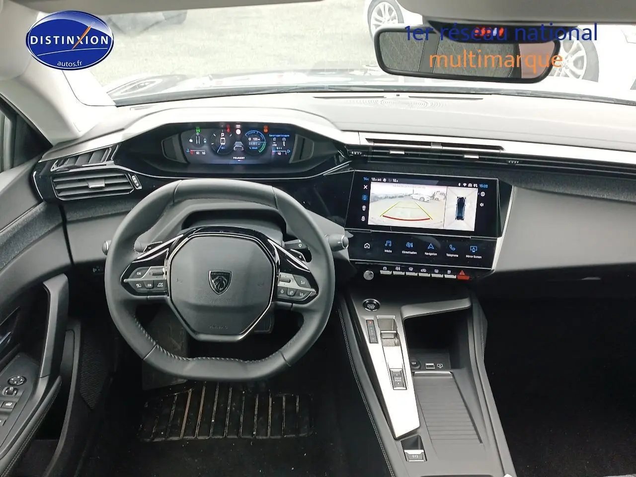 Intérieur Peugeot 408 Hybrid 2024 vu de face, volant cuir multifonction et écran tactile avec caméra de recul.