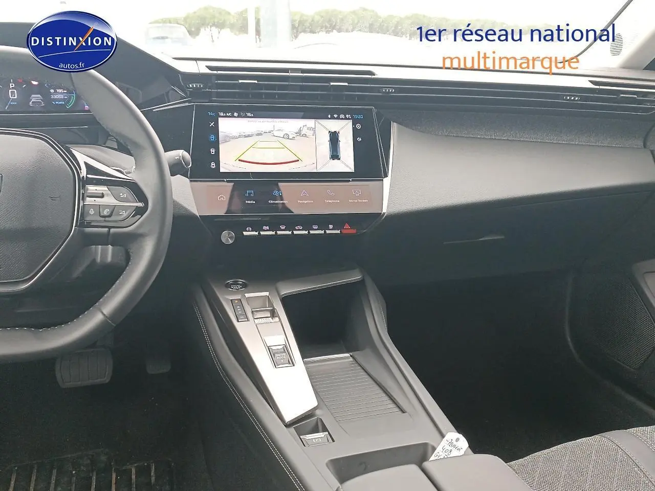 Vue intérieure avant de la Peugeot 408 Hybrid 145 allure 2024, tableau de bord moderne avec écran tactile et console centrale grise.