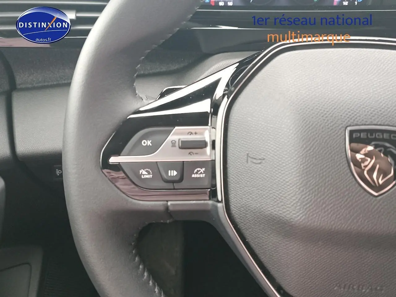 Gros plan sur le volant cuir multifonction de la Peugeot 408 Hybrid 145 allure gris sélénite, avec commandes intégrées.
