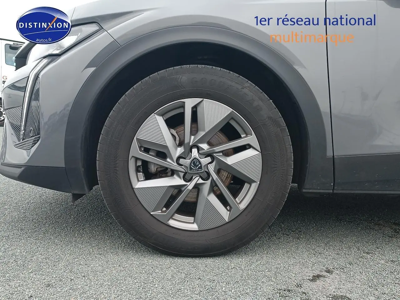 Gros plan sur la roue avant gauche de la Peugeot 408 Hybrid 145 allure gris sélénite avec jante alu au design moderne.