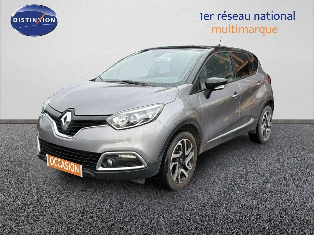 Renault Captur gris Cassiopée avec toit noir, vue 3/4 avant droit sur fond neutre, jantes alliage visibles.