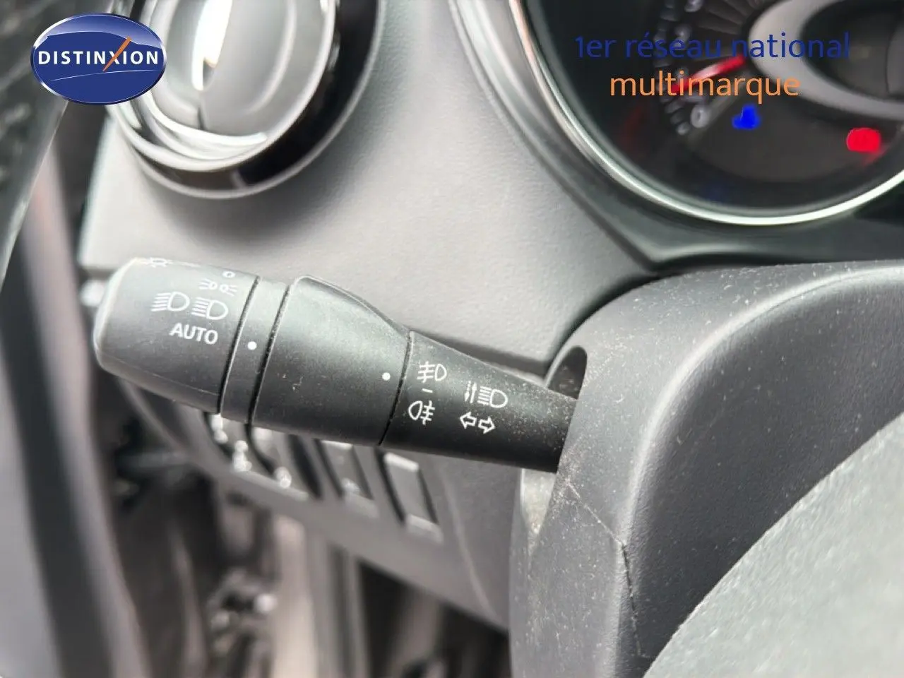 Gros plan sur la commande des phares et clignotants du tableau de bord d’un Renault Captur gris.