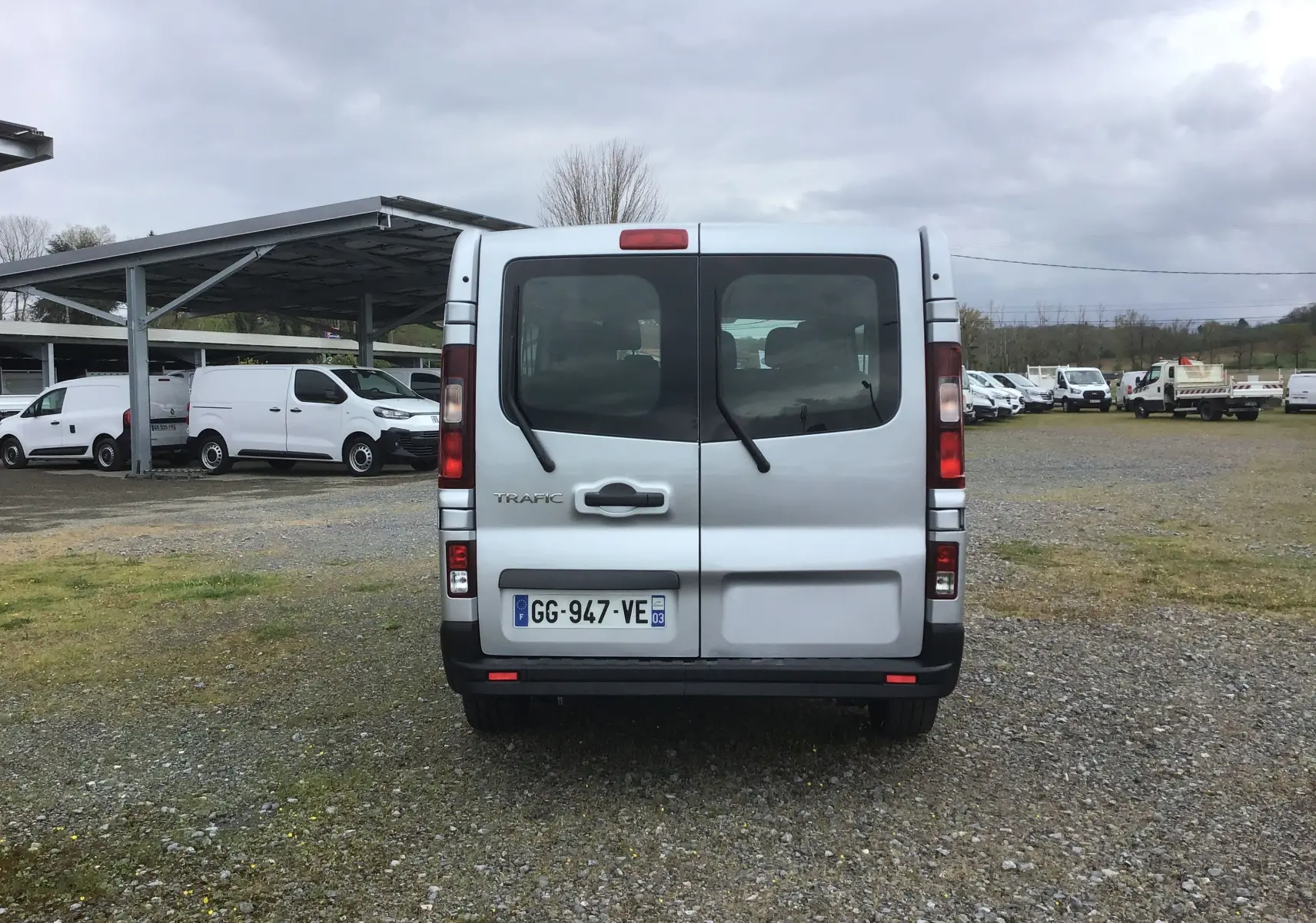 Vue arrière d'un Renault Trafic Combi gris clair métal 2022, avec portes battantes et vitres teintées.