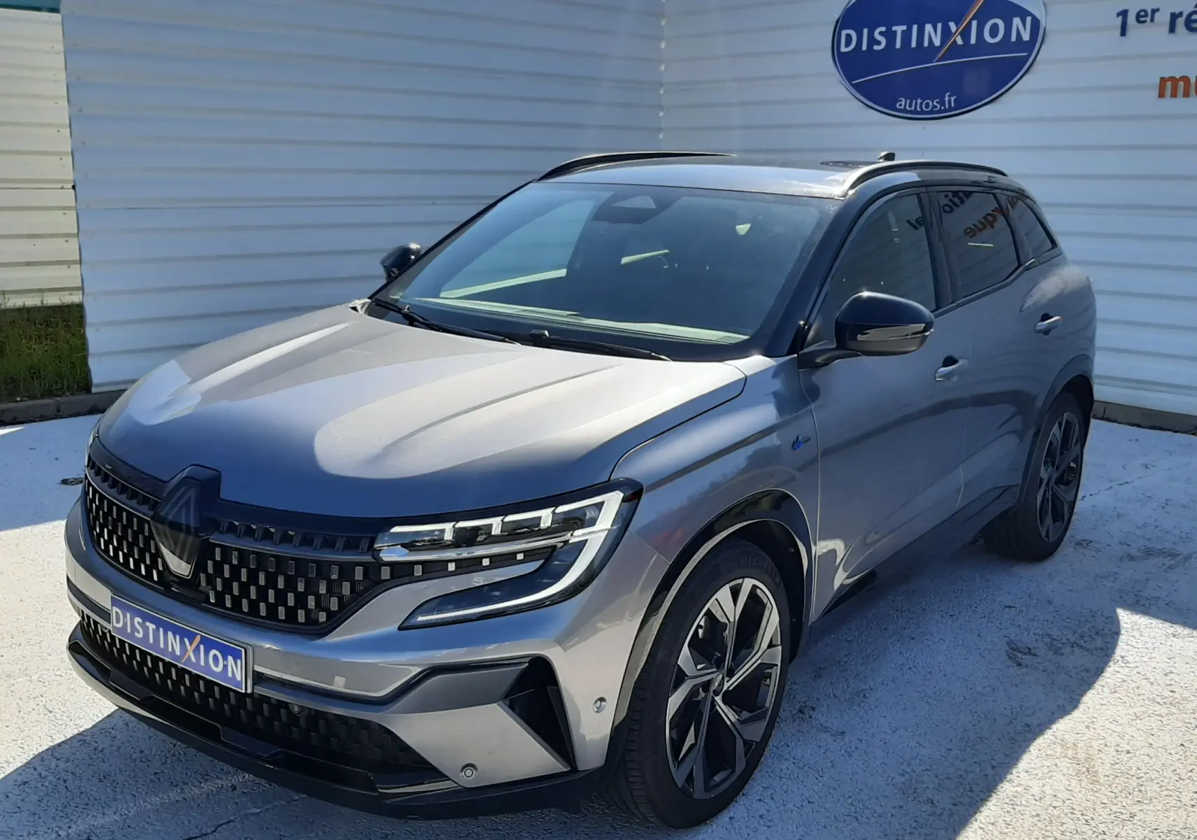 Renault Austral E-Tech hybride gris schiste avec toit noir, vue 3/4 avant droit, calandre et jantes distinctives.