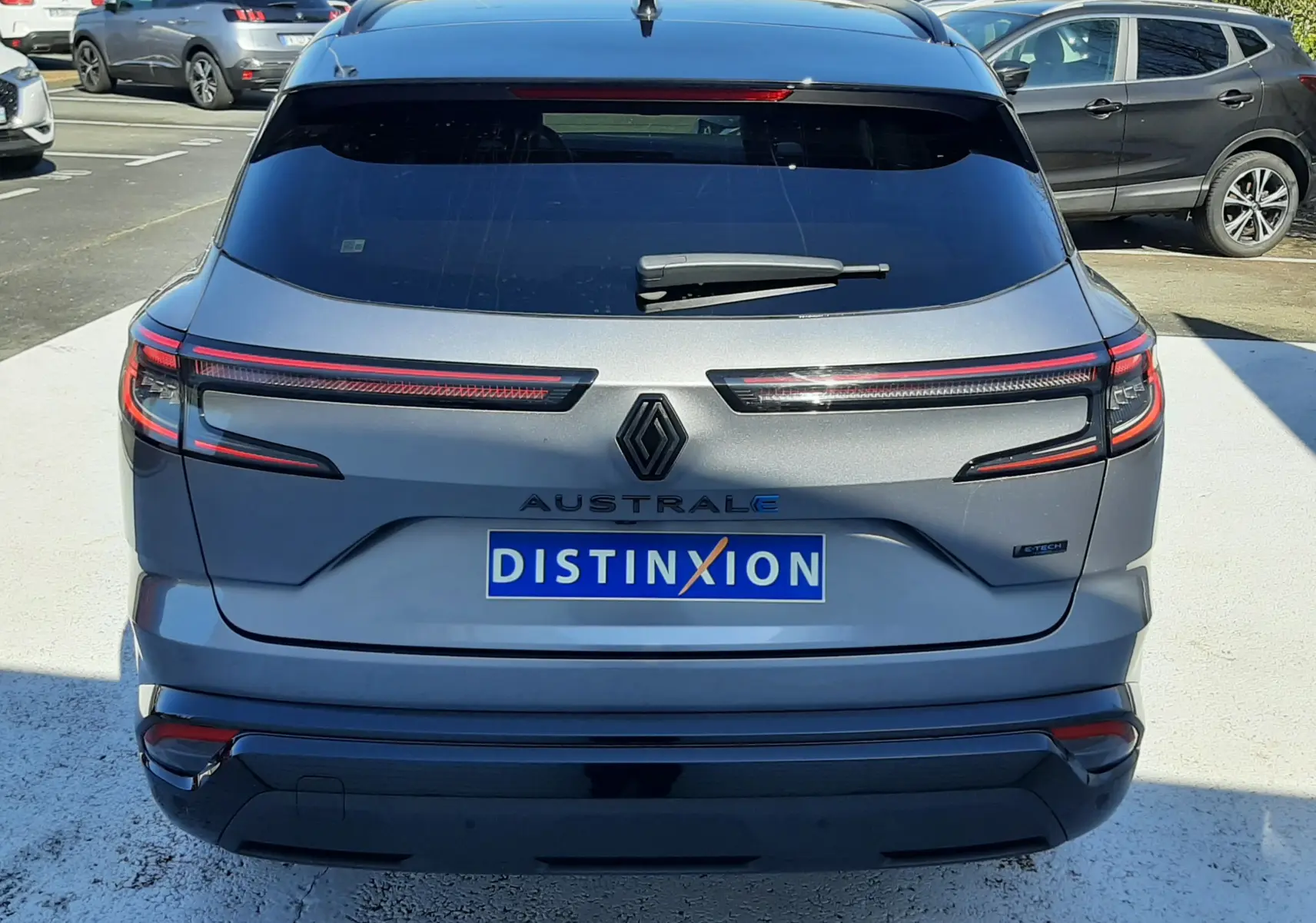 Vue arrière d'un Renault Austral gris schiste avec toit noir, feux LED horizontaux et logo central distinctif.