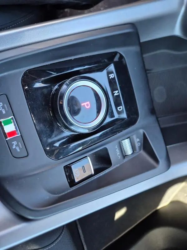 Gros plan sur la molette de sélection de vitesse et commandes centrales noires de l'Alfa Romeo Tonale bleu 2025.