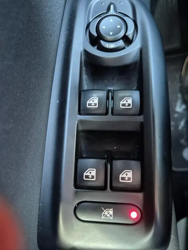 Gros plan sur les commandes de lève-vitres et rétroviseurs électriques dans l'habitacle noir de l'Alfa Romeo Tonale 2025.