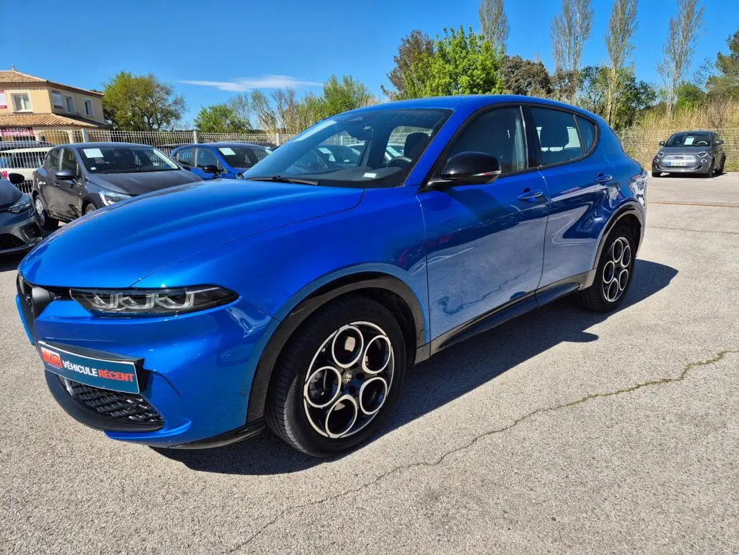 Alfa Romeo Tonale bleu en 3/4 avant droit, avec jantes alliage 18 pouces et rétroviseurs noirs brillants.
