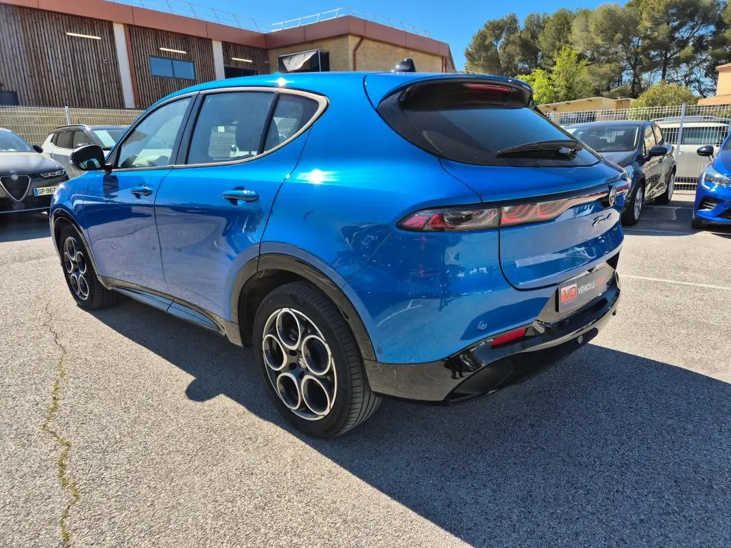 Vue 3/4 arrière droite d'une Alfa Romeo Tonale bleu 2025 avec jantes alliage 18 pouces et feux arrière allongés.