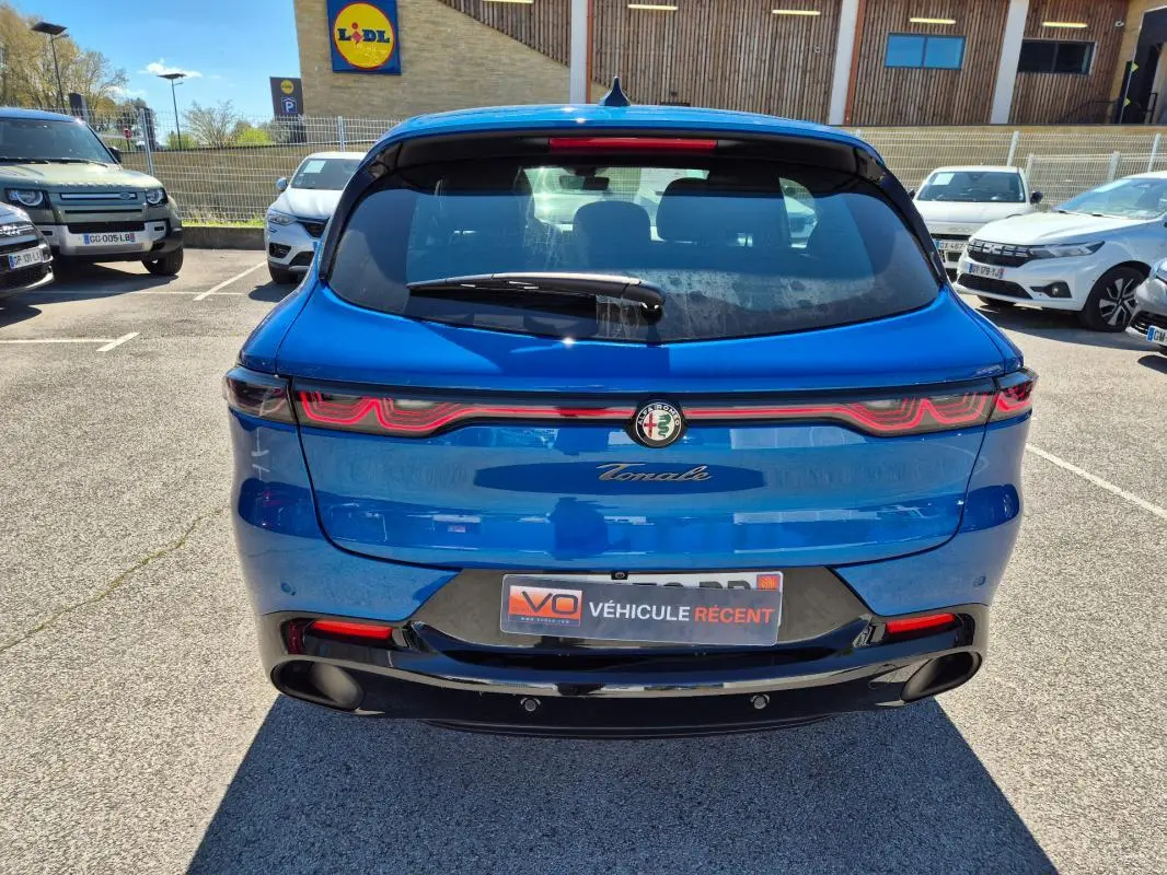 Vue arrière d'une Alfa Romeo Tonale bleu 2025 avec feux LED distinctifs et double sortie d'échappement noire.