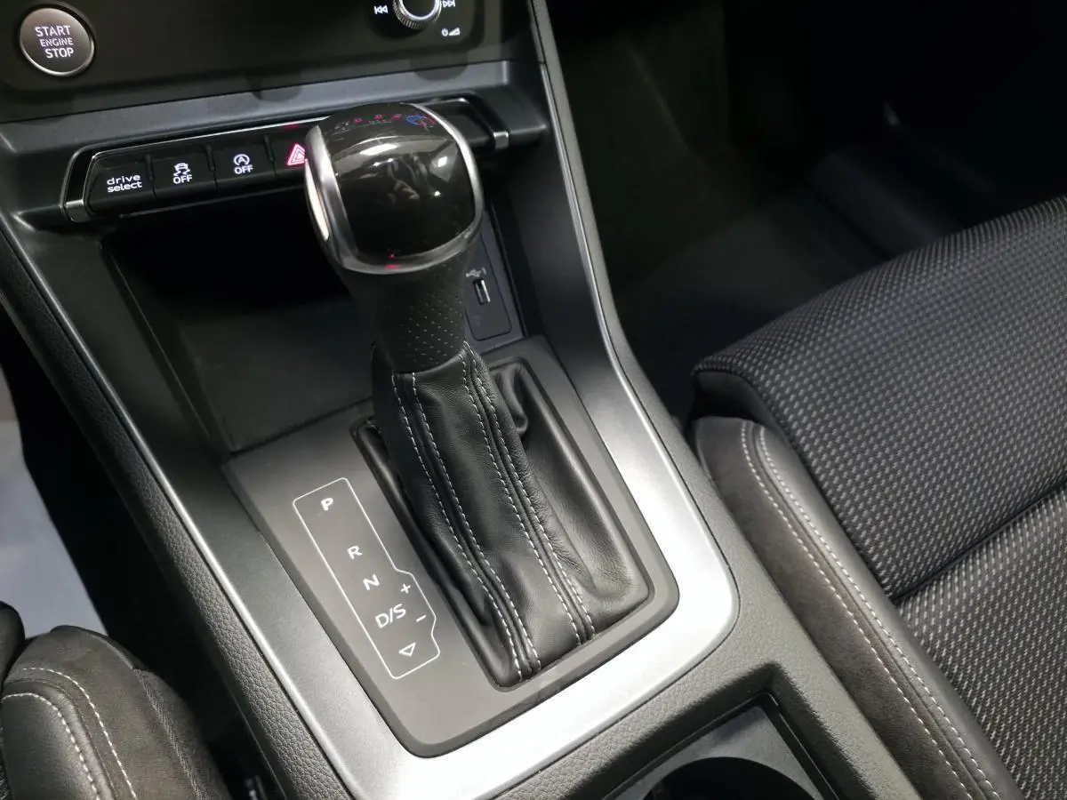 Gros plan sur la console centrale et levier de vitesse automatique cuir noir de l'Audi Q3 S-Line 2019.
