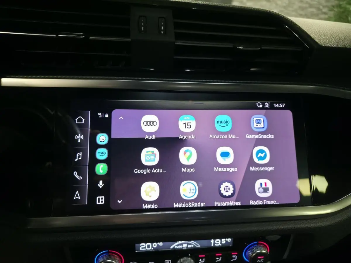 Écran tactile central de l’Audi Q3 blanc 2019 affichant Apple CarPlay et applications connectées.