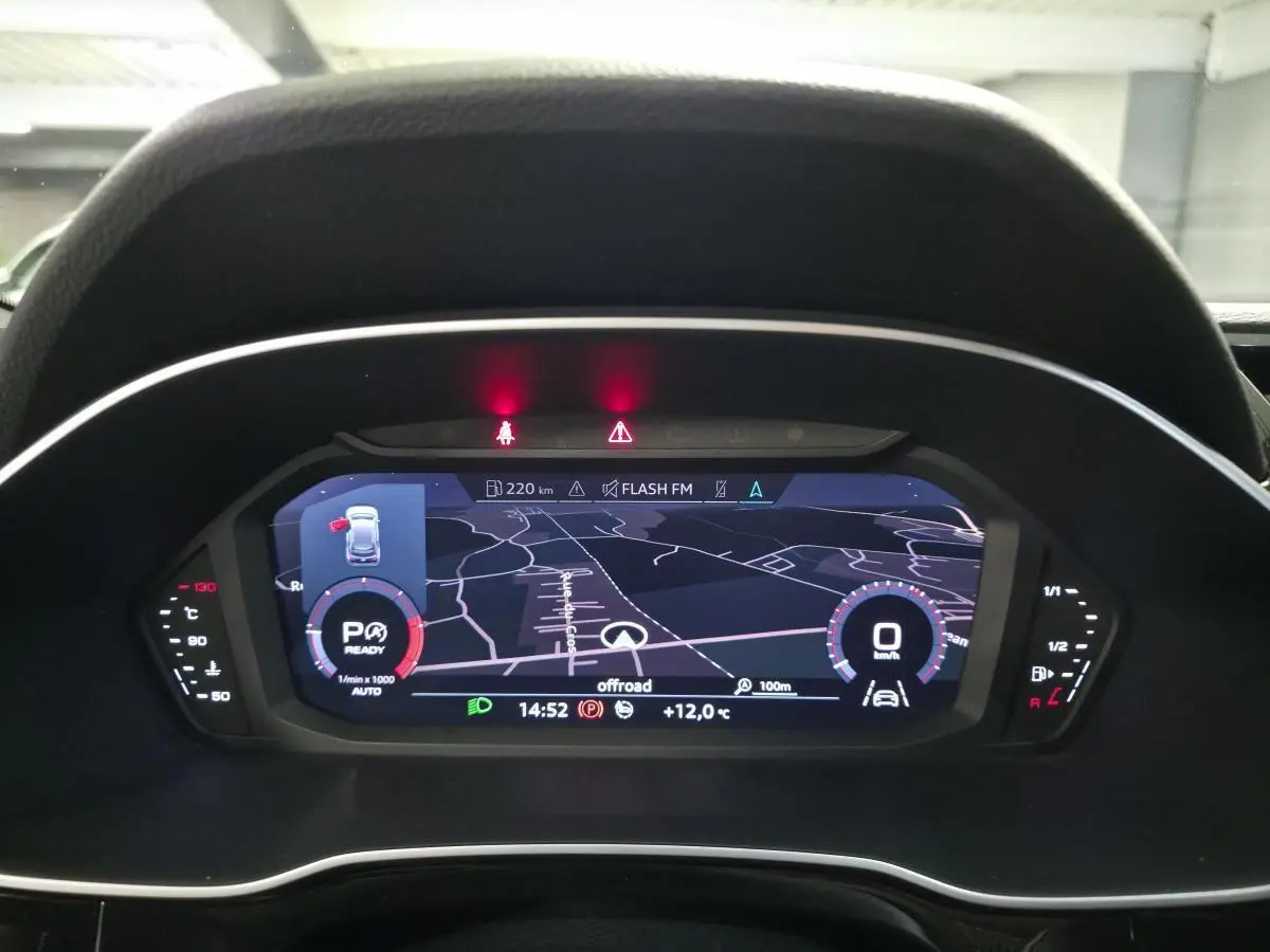 Vue rapprochée du tableau de bord numérique de l'Audi Q3 2019, affichant la navigation et les indicateurs de conduite.