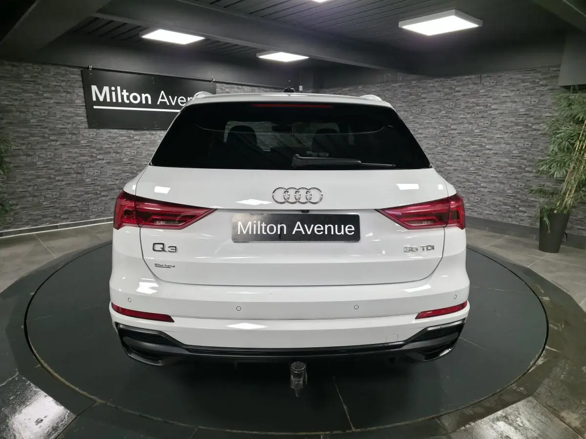 Vue arrière d’un Audi Q3 blanc 2019 avec hayon électrique et crochet d’attelage dans un showroom.