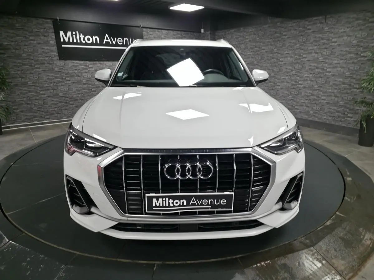 Vue avant d'un Audi Q3 blanc S-Line 2019 avec calandre noire et logo Audi bien visible.