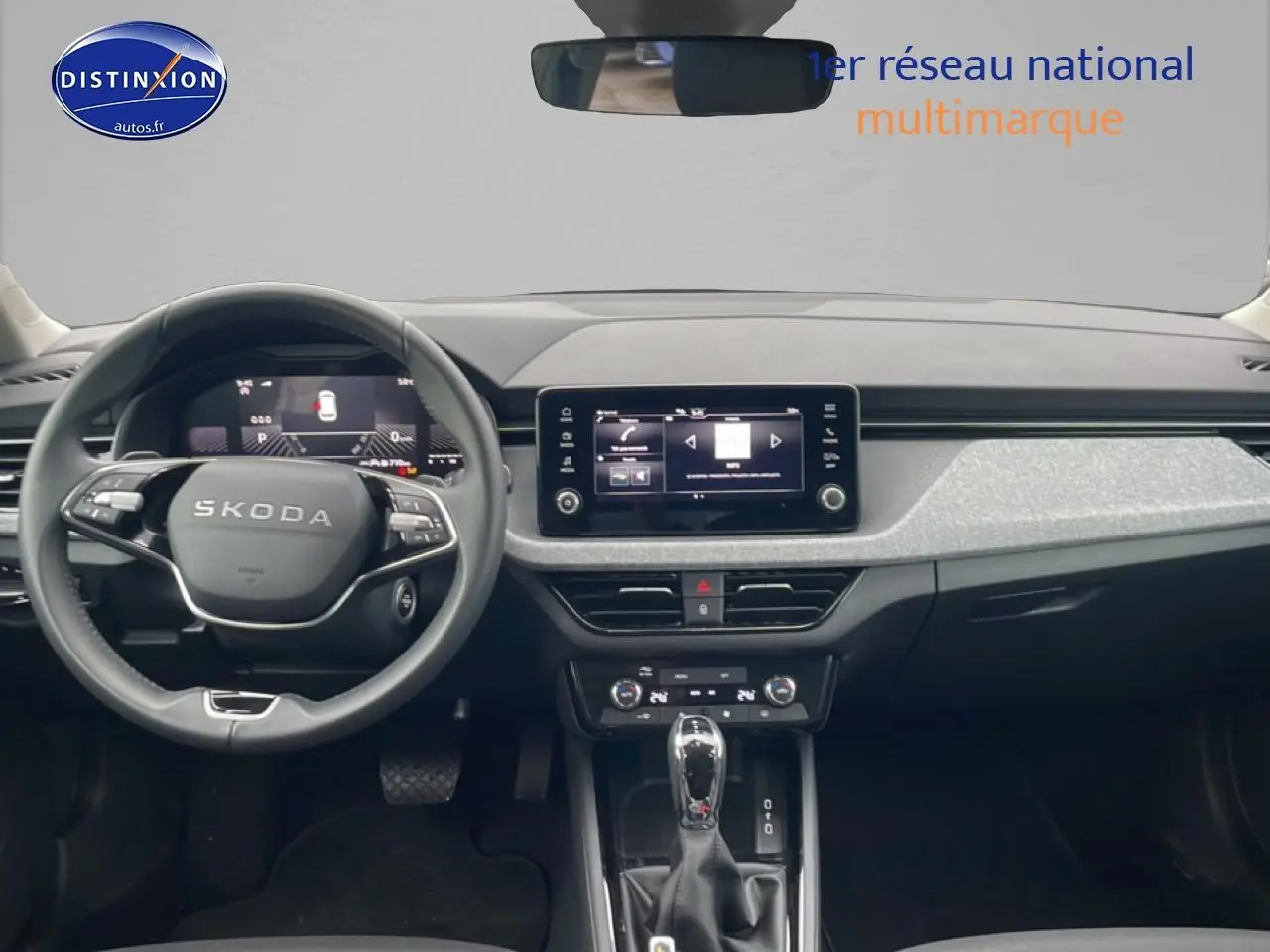 Vue intérieure avant du Skoda Kamiq 2025, tableau de bord noir avec écran tactile central et volant multifonction cuir.