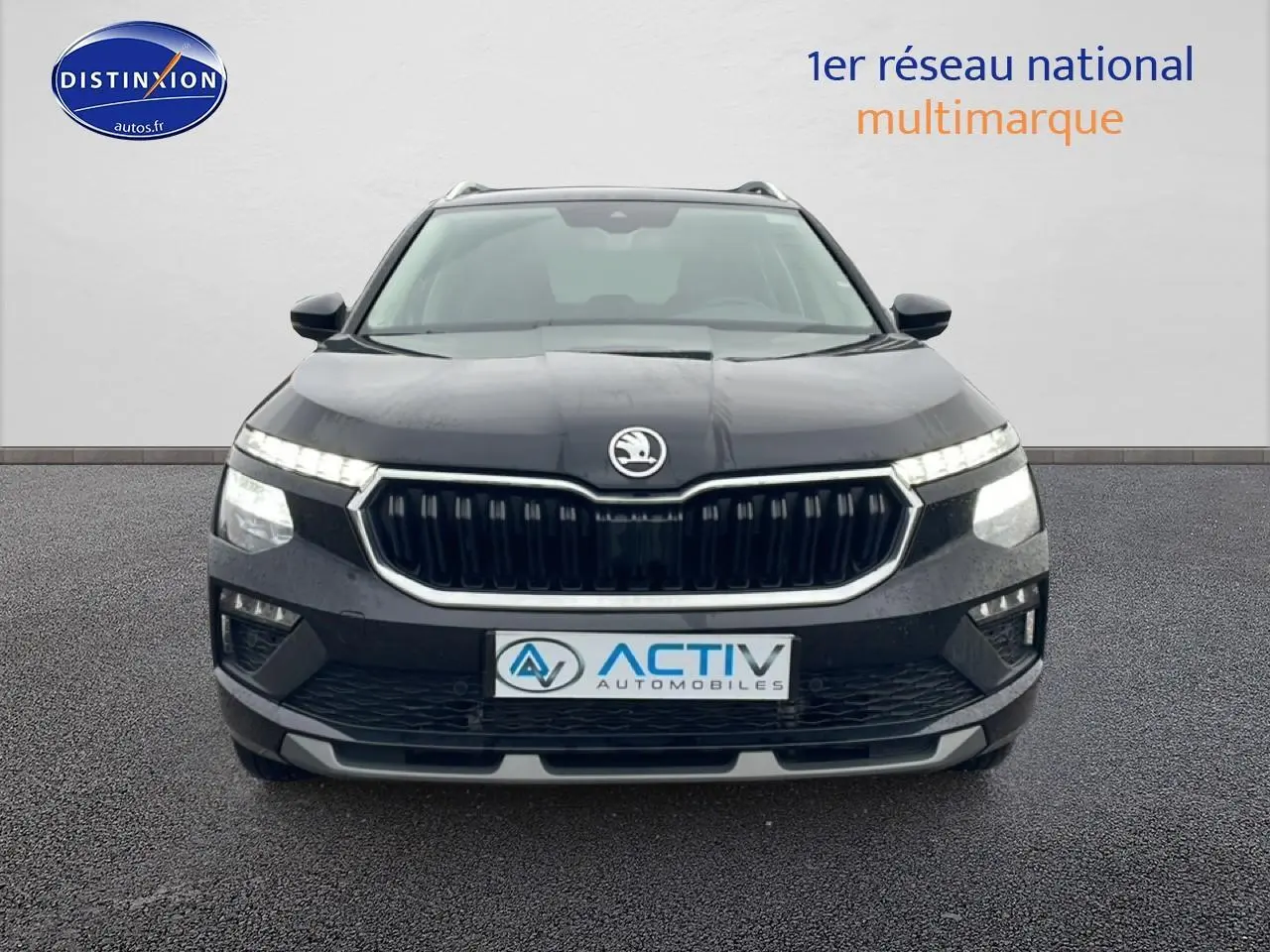 Vue avant d'un Skoda Kamiq noir 2025 avec calandre chromée et feux LED allumés.