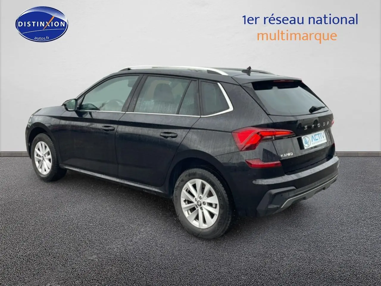 Vue 3/4 arrière droite d’un Skoda Kamiq noir 2025 avec jantes alu et barres de toit chromées.