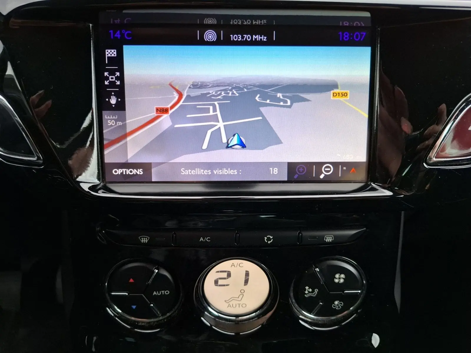 Vue rapprochée du tableau de bord de la Citroën DS3 gris clair 2015, mettant en valeur l’écran GPS et la climatisation automatique.