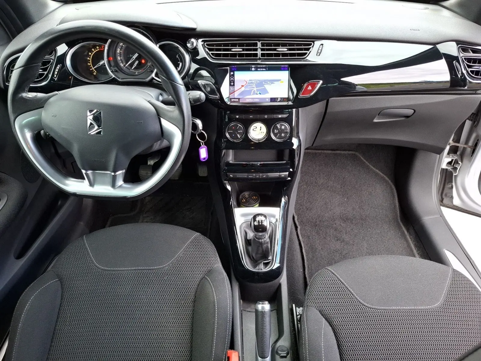 Vue intérieure avant de la Citroën DS3 1.2 PureTech 110 so chic avec tableau de bord noir brillant et écran GPS tactile.