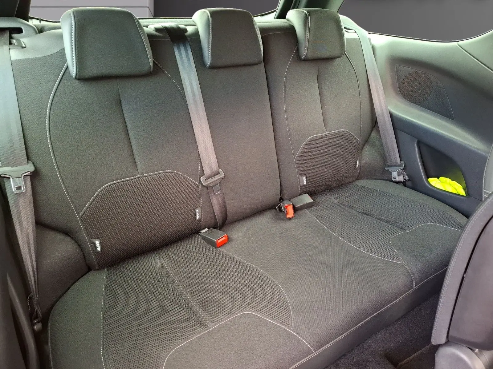 Vue intérieure de la banquette arrière noire d'une Citroën DS3 2015 avec ceintures et système Isofix visibles.