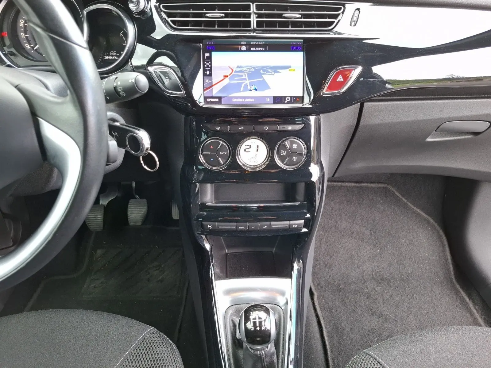 Vue intérieure centrée sur la console centrale d'une Citroën DS3 1.2 PureTech 110 so chic avec écran GPS et levier de vitesse manuel.