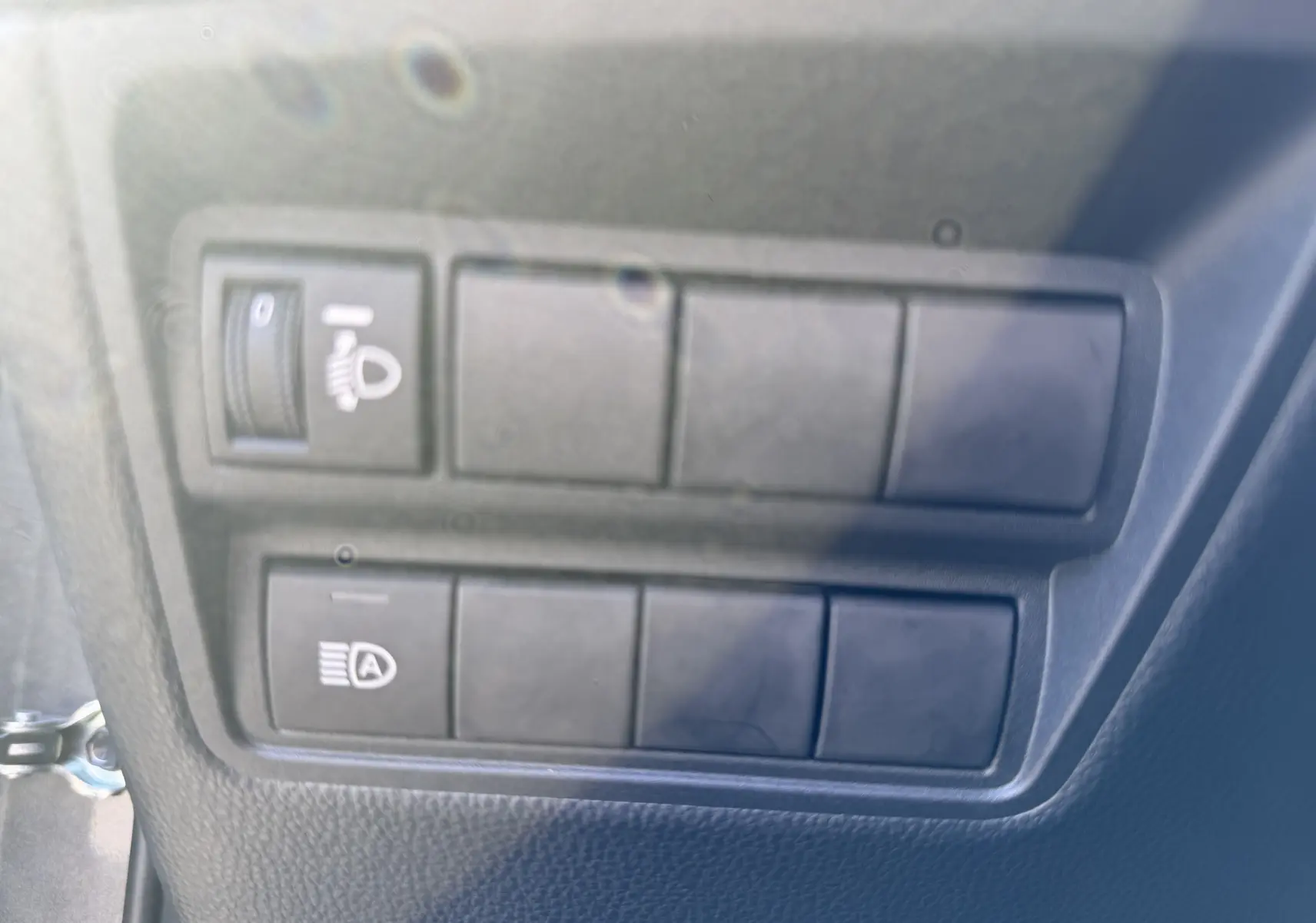 Gros plan sur les commandes d’éclairage intérieures noires du Toyota Yaris Cross 2026, finition Trend gris atlas metal.