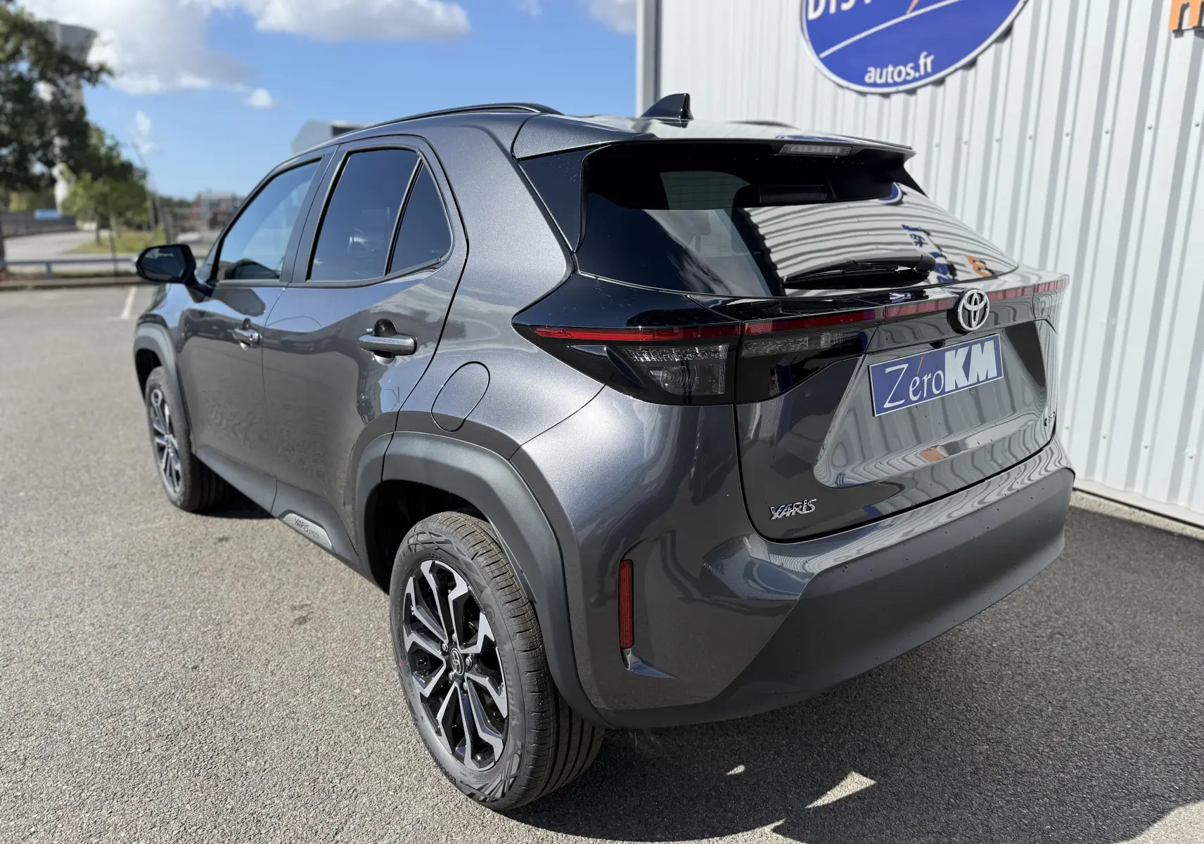 Vue 3/4 arrière droite d'une Toyota Yaris Cross 2026 gris atlas métal avec feux arrière noirs et jantes alliage.