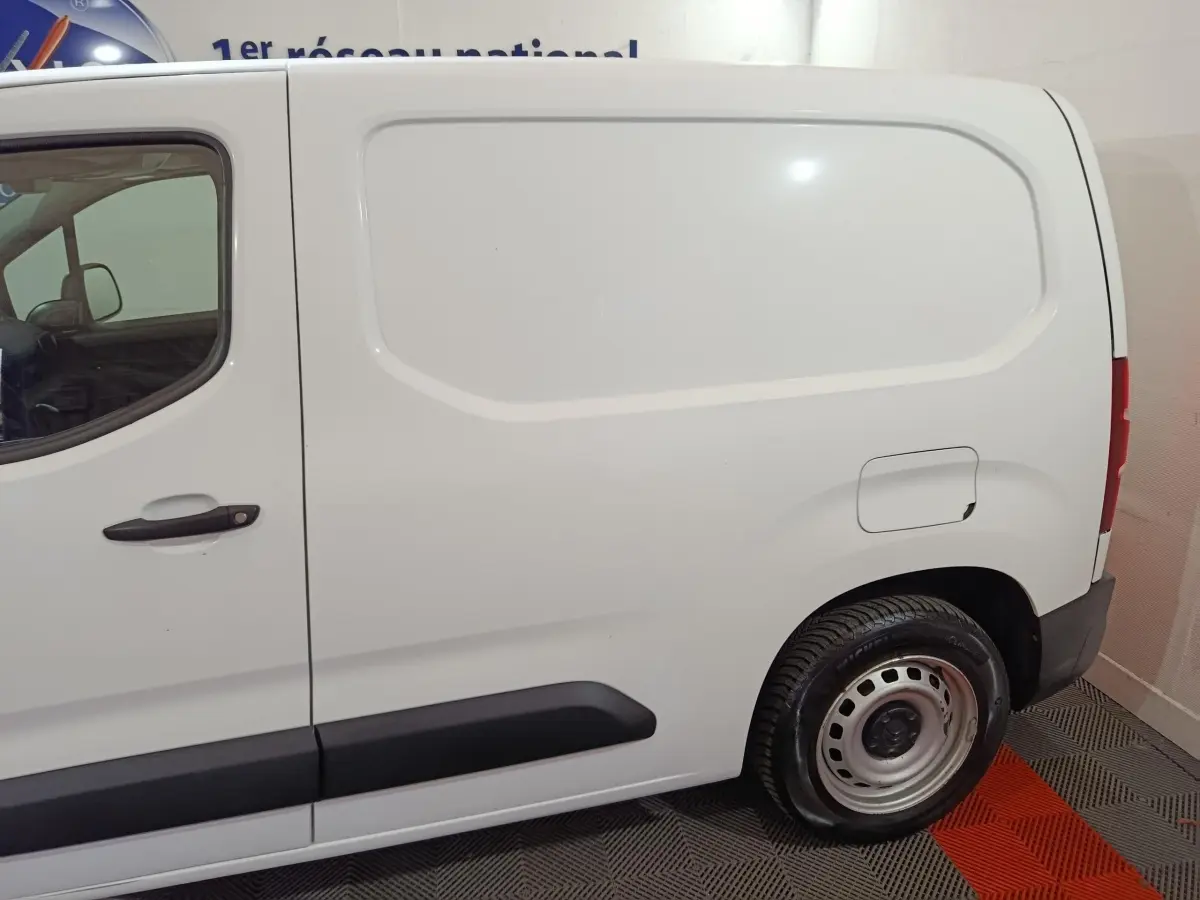 Vue de profil côté droit du Citroën Berlingo blanc utilitaire avec porte latérale pleine et jante acier.
