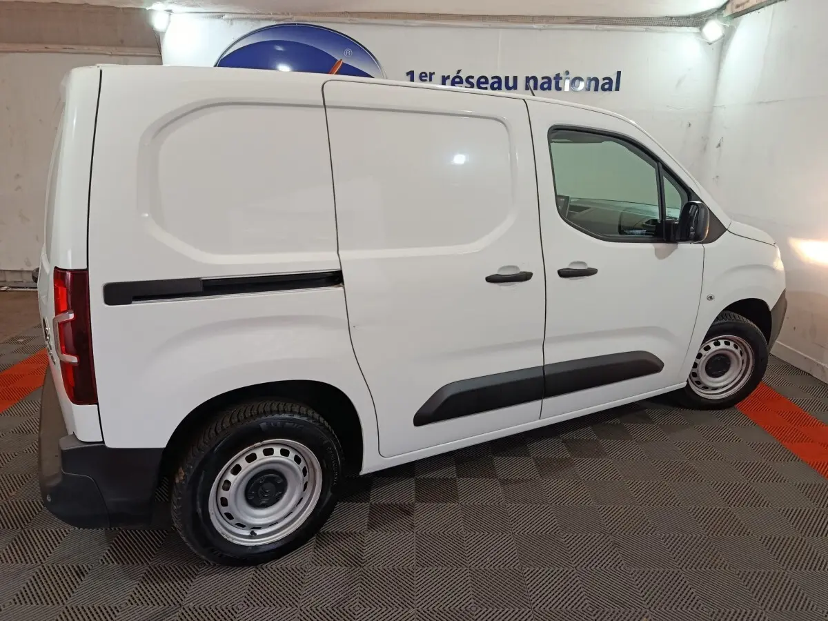 Vue de profil droit du Citroën Berlingo blanc utilitaire, avec portes latérales pleines et jantes acier simples.