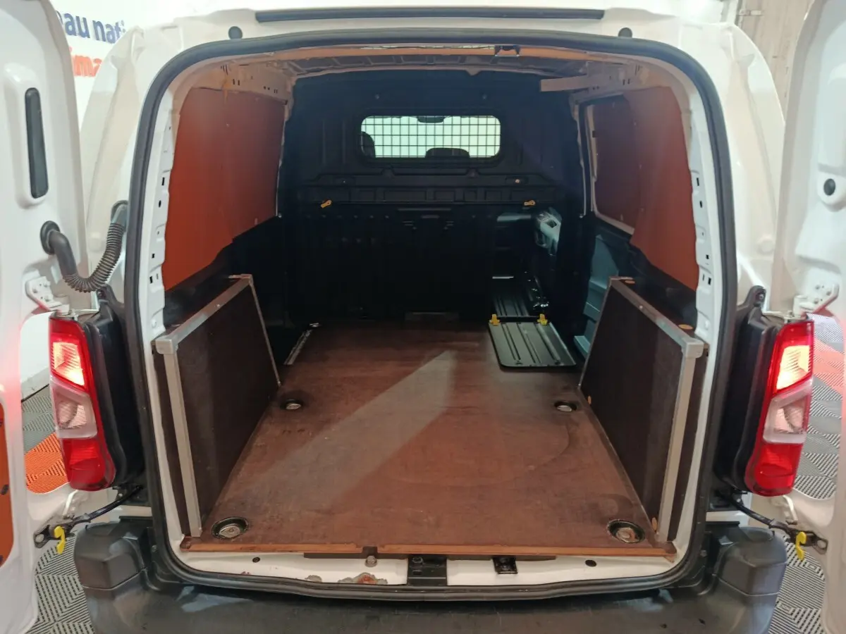 Vue arrière ouverte du Citroën Berlingo blanc 2021, montrant l’espace de chargement vide et la cloison pleine noire.