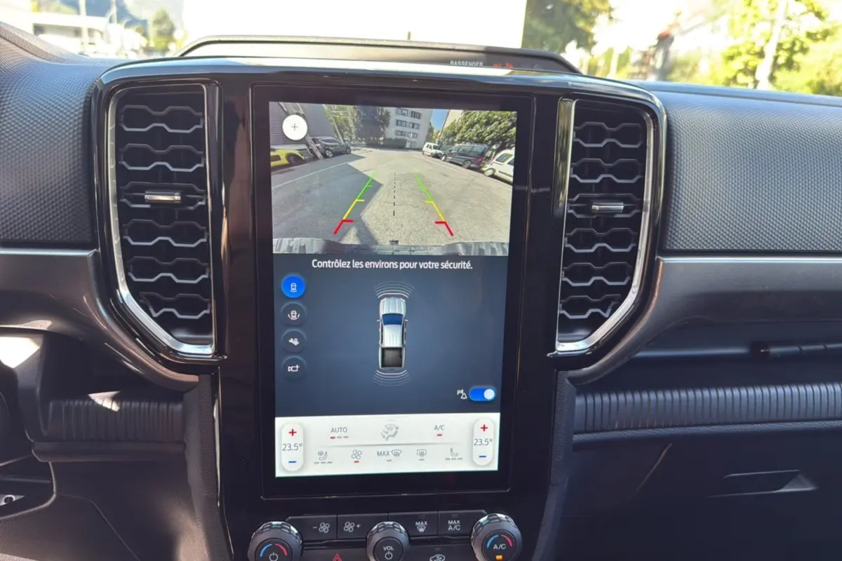Vue rapprochée de l’écran central tactile du Ford Ranger blanc glacier, affichant la caméra de recul et la climatisation automatique.