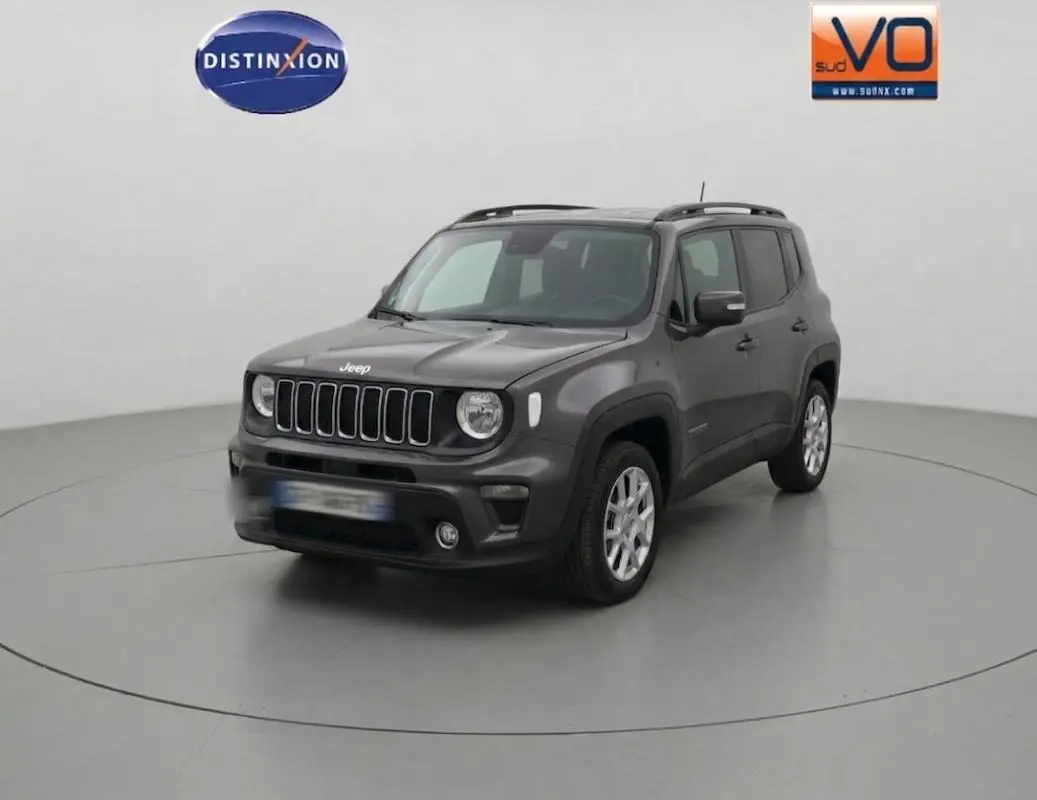 Jeep Renegade bleu foncé en 3/4 avant droit, avec barres de toit et jantes alliage 17 pouces visibles.