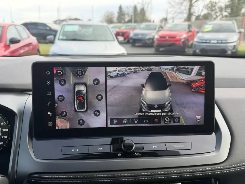 Écran intérieur du Nissan Qashqai Hybrid e-POWER 2025 montrant la vue 360° et caméra arrière du véhicule blanc nacré.