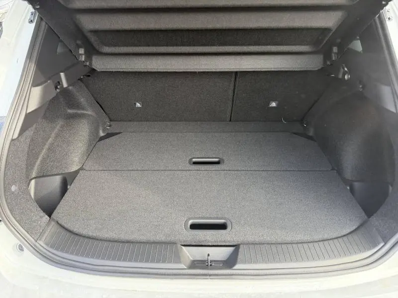 Vue intérieure du coffre ouvert du Nissan Qashqai Hybrid e-POWER blanc nacré, montrant un espace de rangement plat et spacieux.