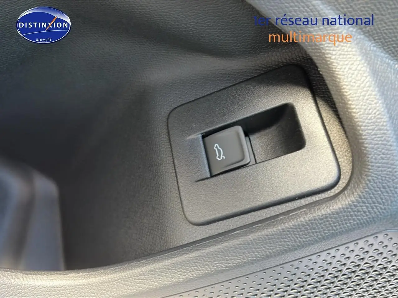Gros plan sur le bouton d'ouverture du coffre dans l'habitacle du CUPRA Formentor gris graphene.