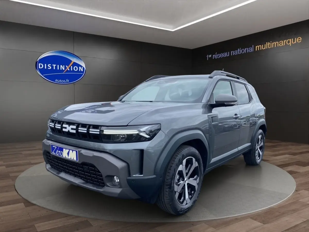 SUV Dacia Duster Journey Hybrid 140 gris foncé vu en 3/4 avant droit avec calandre et phares LED distinctifs.