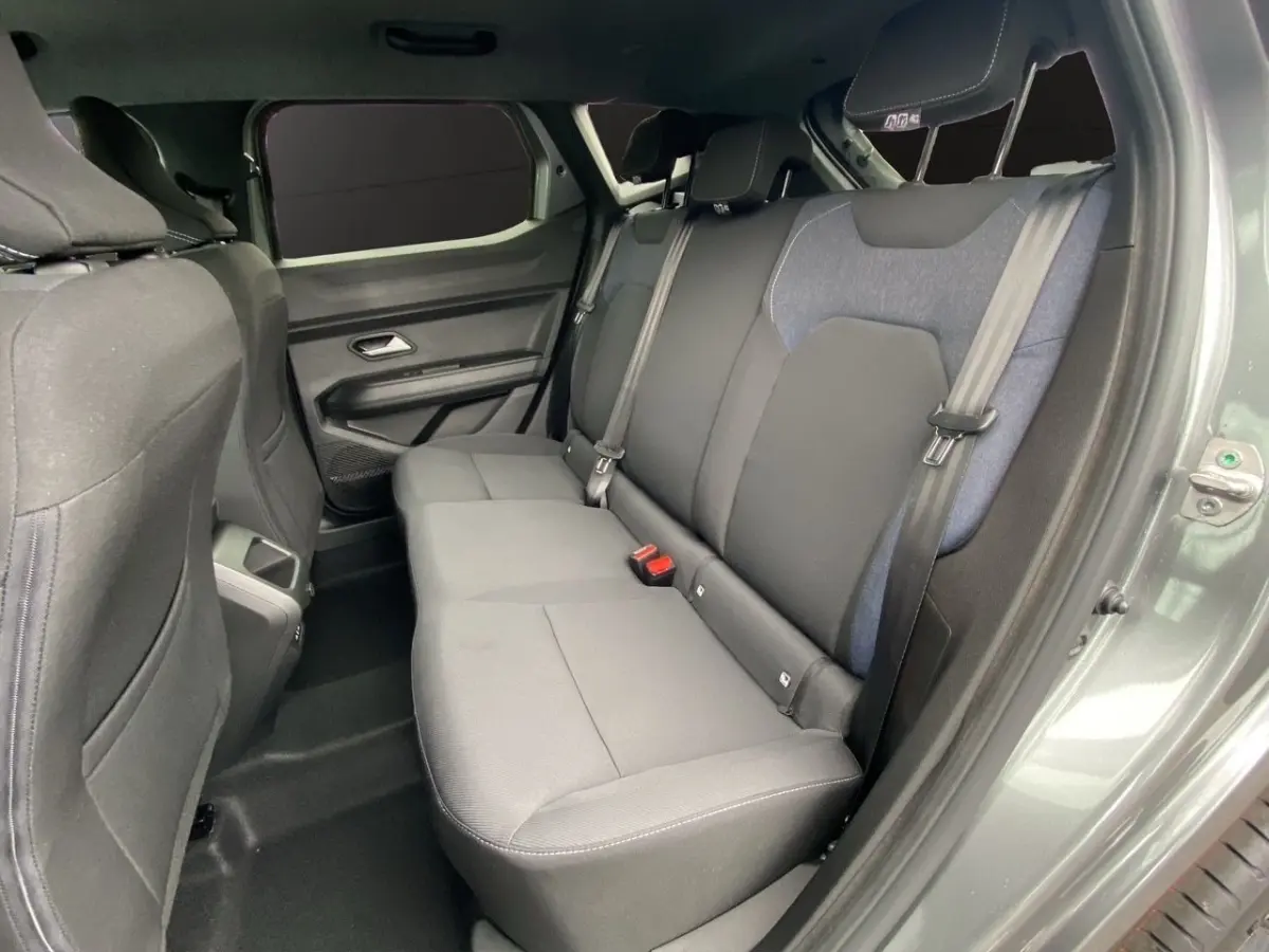 Vue intérieure côté droit sur la banquette arrière grise du Dacia Duster Journey Hybrid 140 2025 avec ceinture de sécurité.