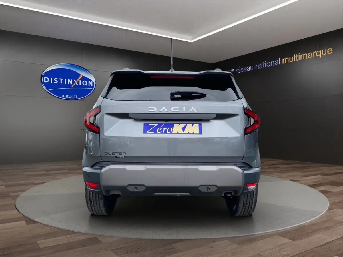 Vue arrière d'un Dacia Duster Journey Hybrid 140 gris foncé avec feux LED et logo DACIA bien visible.