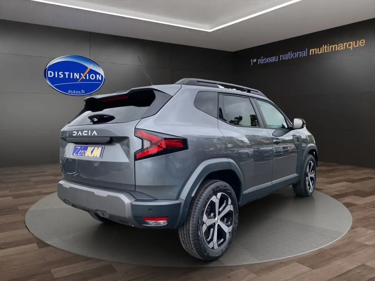 Vue 3/4 arrière droite du Dacia Duster Journey Hybrid 140 gris foncé avec jantes noires et toit noir.